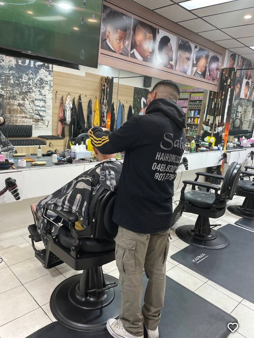 Barber cutting hair inside Saba Barbershop